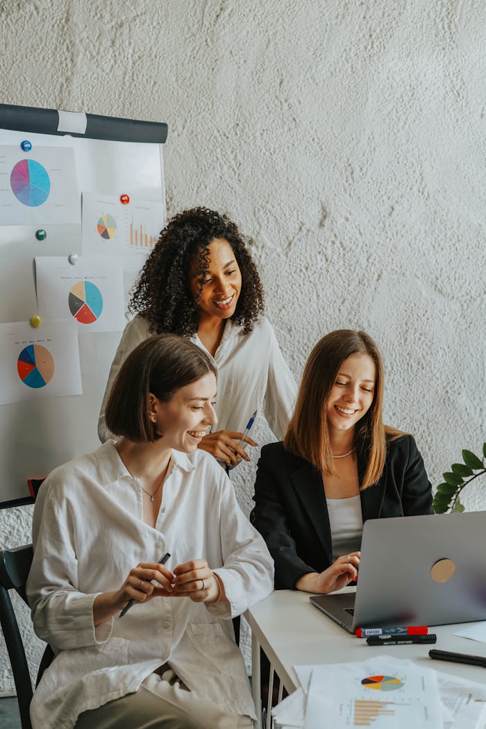 Women in the Office Looking at Laptop Screen Smiling